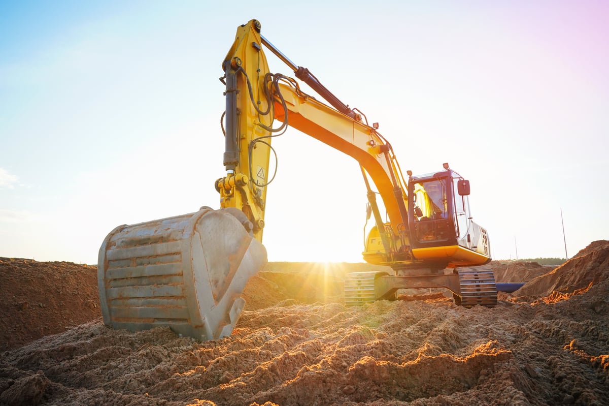 Bagger auf Baustelle bei Sonnenuntergang