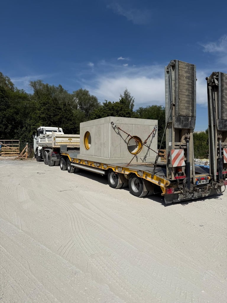 Schwere Zugmaschine beim Transport eines großen industriellen Zylinderbehälters auf Tieflader mit Hydraulikkran an einem Rastplatz